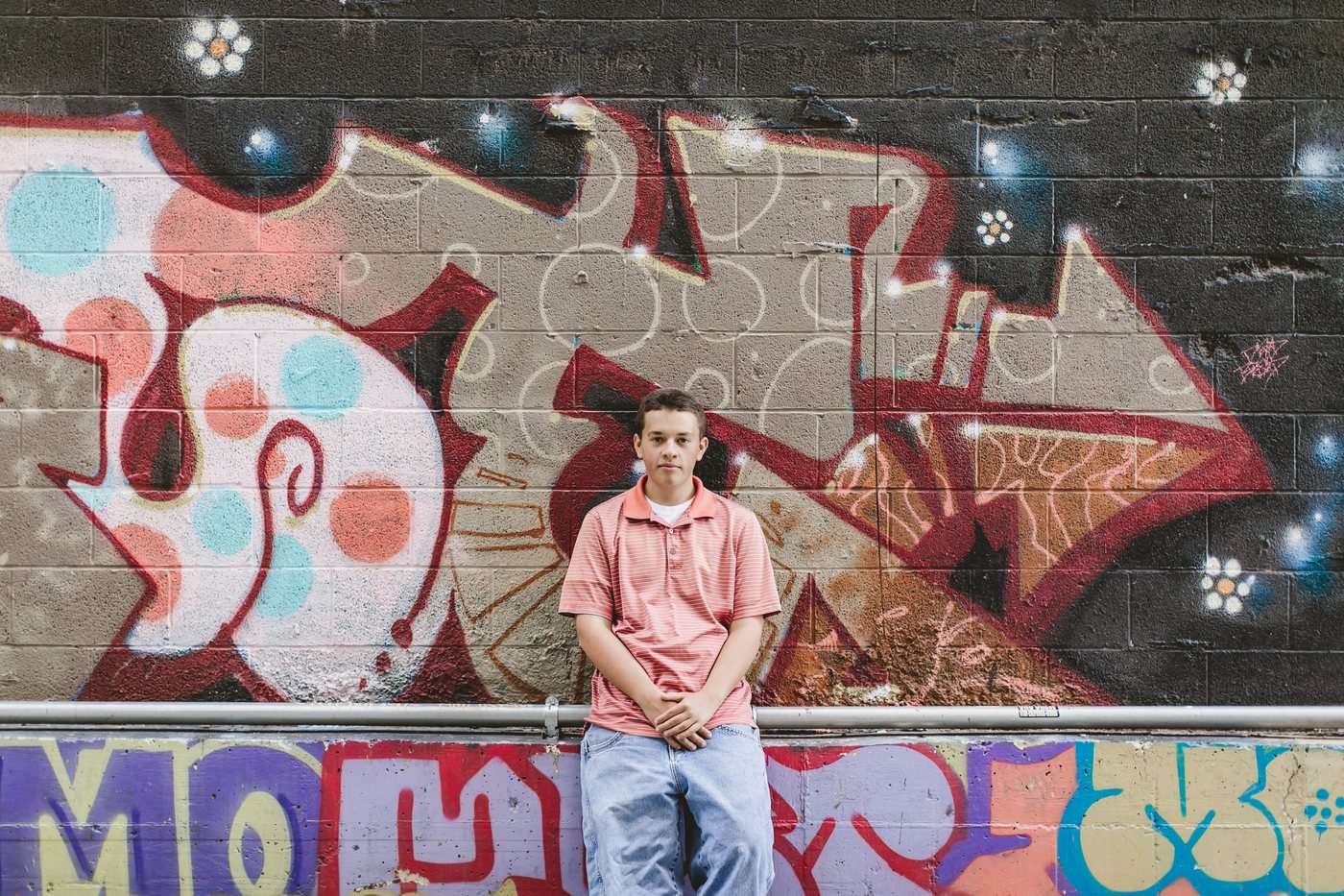 Isaac standing in front of colorful mural art