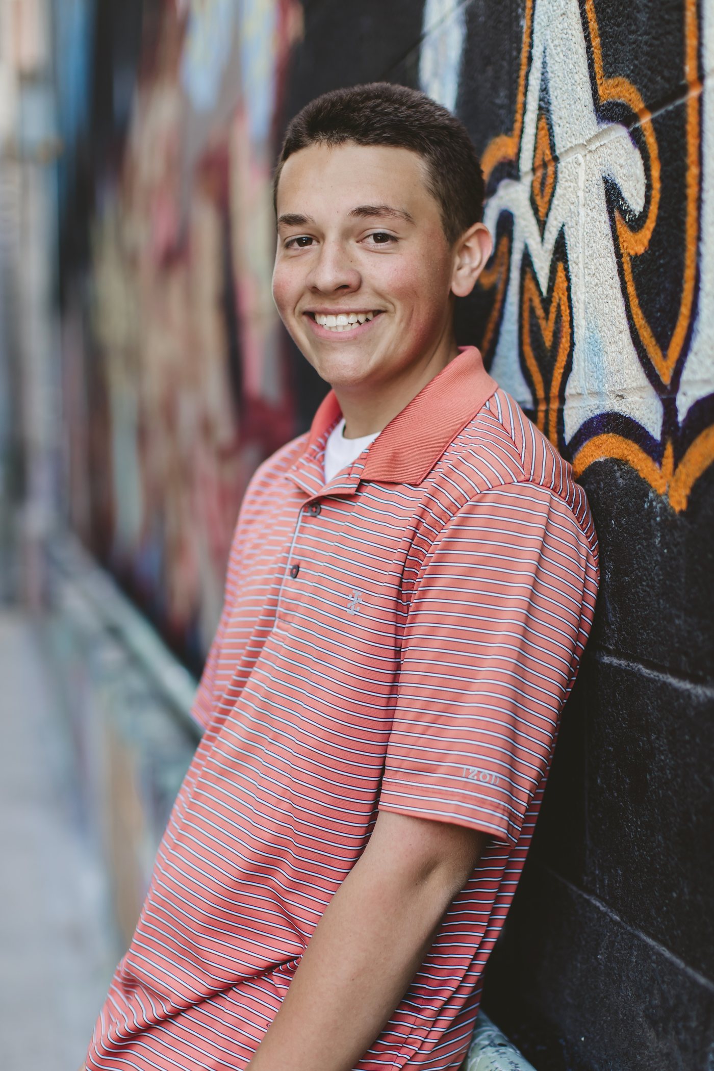 Isaac standing next to colorful mural art