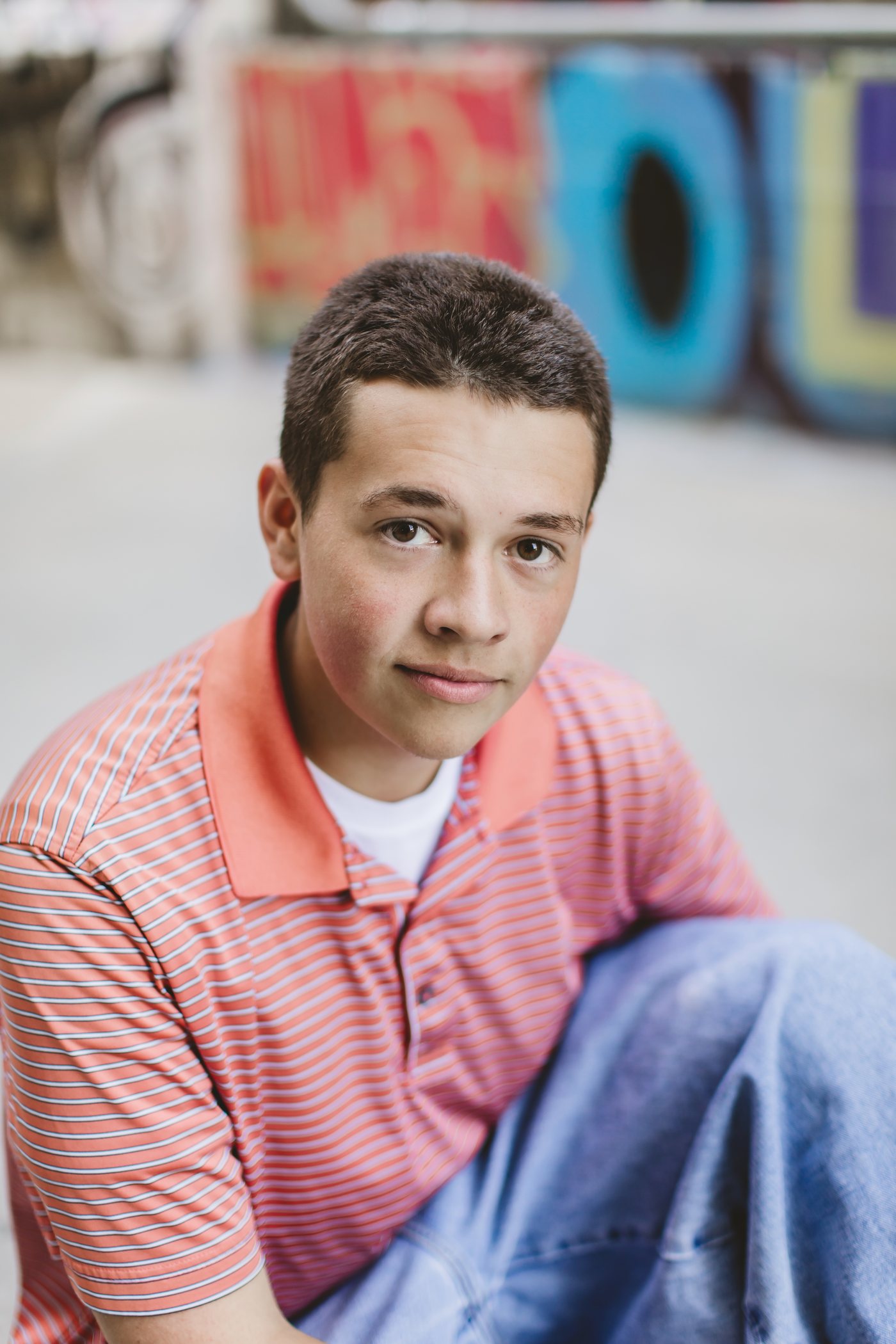 Isaac seated with colorful mural art behind him