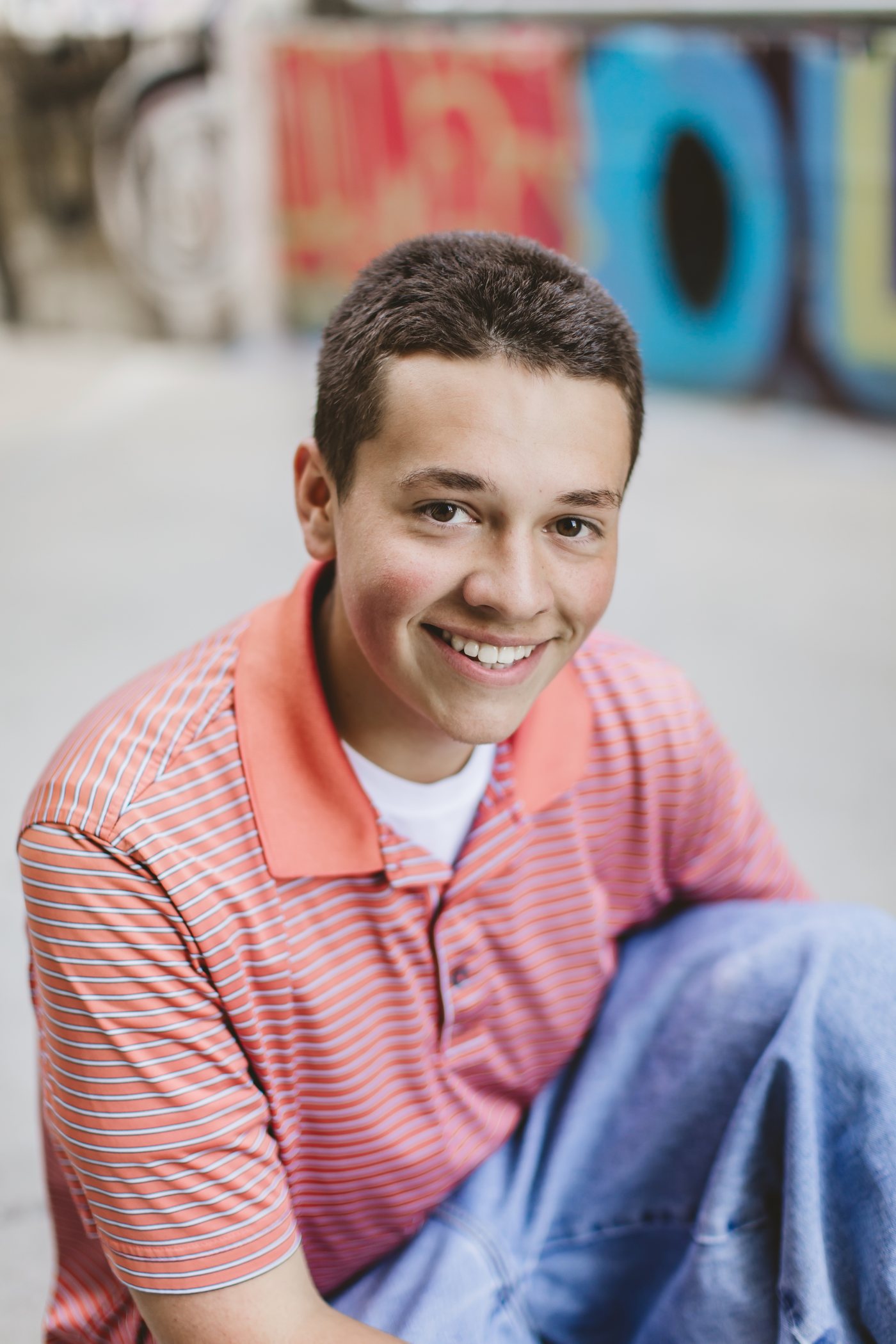 Isaac smiling with colorful mural art in the background