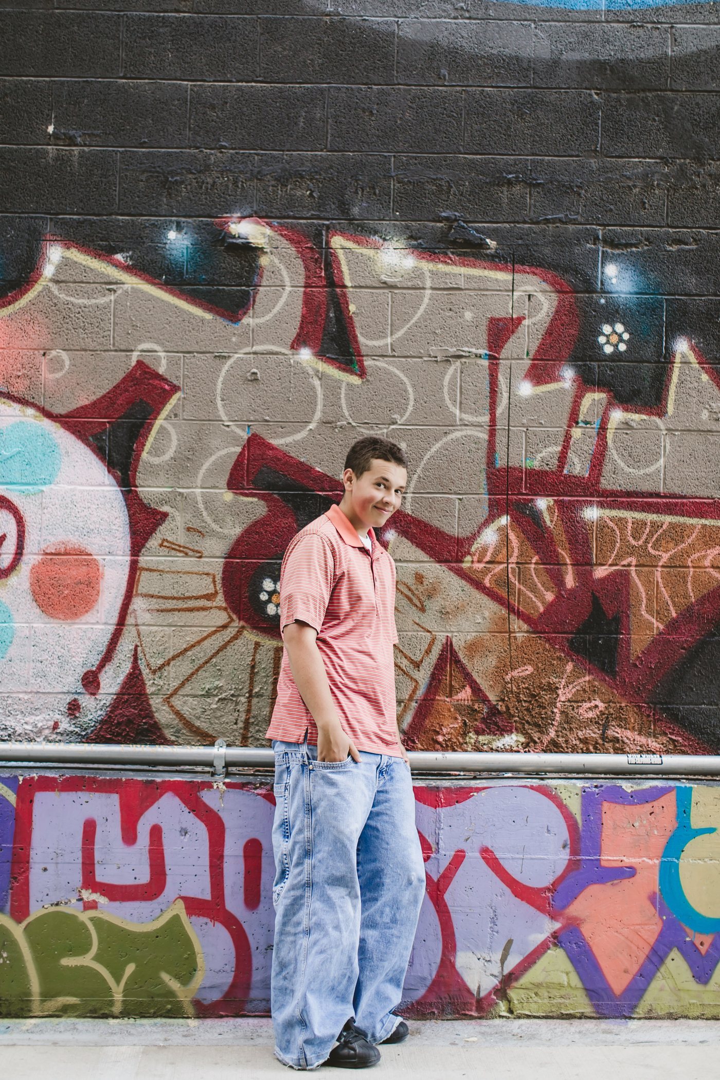 Isaac standing by red mural art