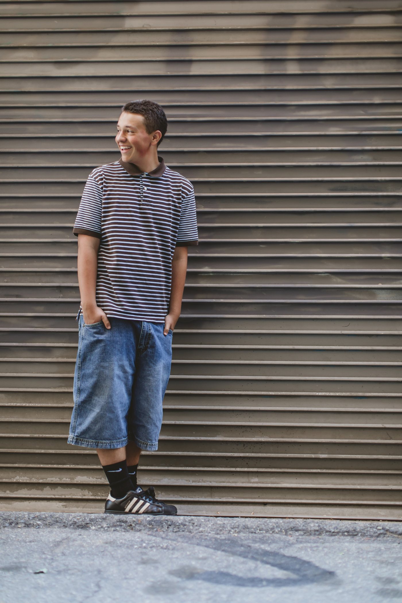 Isaac standing in front of a corrugated metal wall